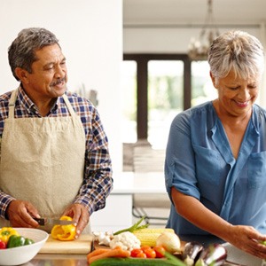 An elderly couple cooking healthy foods