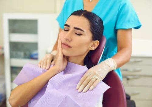 Woman in a dental chair receiving treatment for tooth infection.