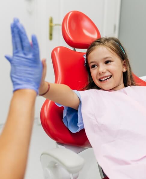 Child giving children's dentist a high five