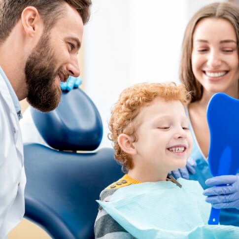 Child looking at smile in mirror during first visit