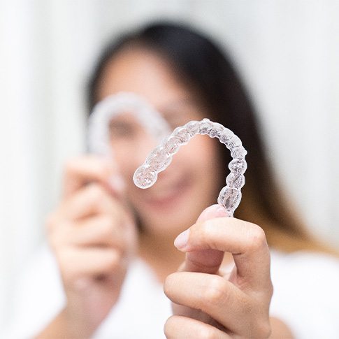 Closeup of patient holding clear aligners