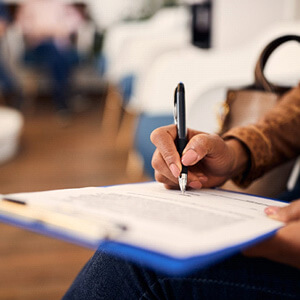 woman filling out dental insurance form in lobby