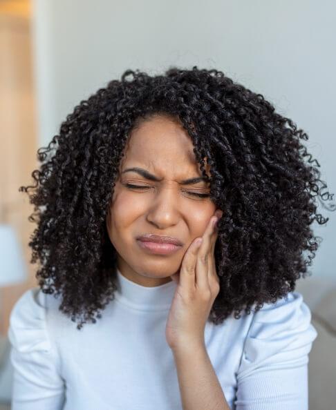 Woman in pain before visiting her emergency dentist