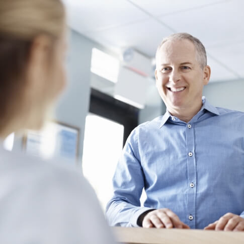 Dental patient discussing the cost of emergency dentistry treatment with dental team member