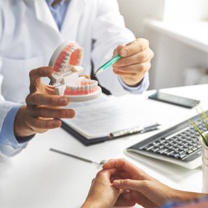 A patient and dentist talking about dental implant work