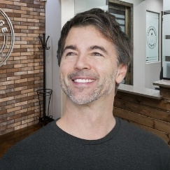 Man in black shirt smiling in dental office
