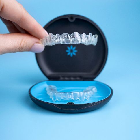 Patient placing clear aligners in Candid case