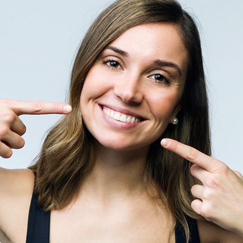 Woman pointing to smile