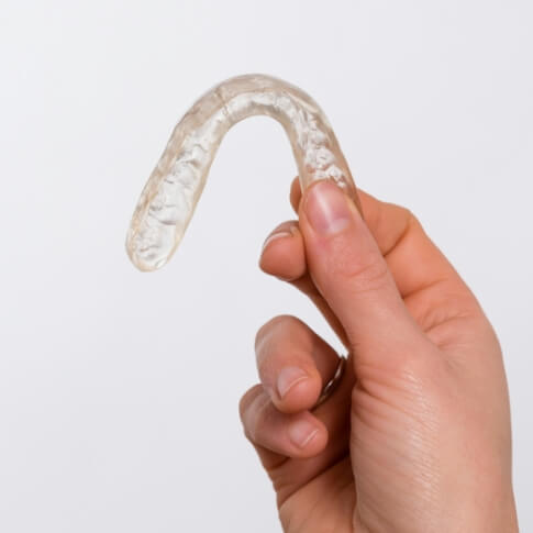 Hand holding a custom oral appliance for sleep apnea