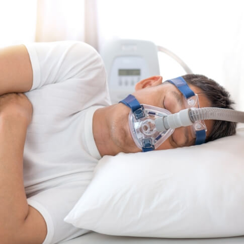 Person with CPAP face mask sleeping
