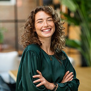Woman in green shirt smiling in office