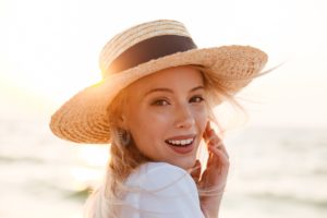 Smiling woman in a straw hat at the beach