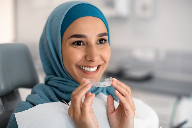 Patient with bruxism putting on their clear aligners 