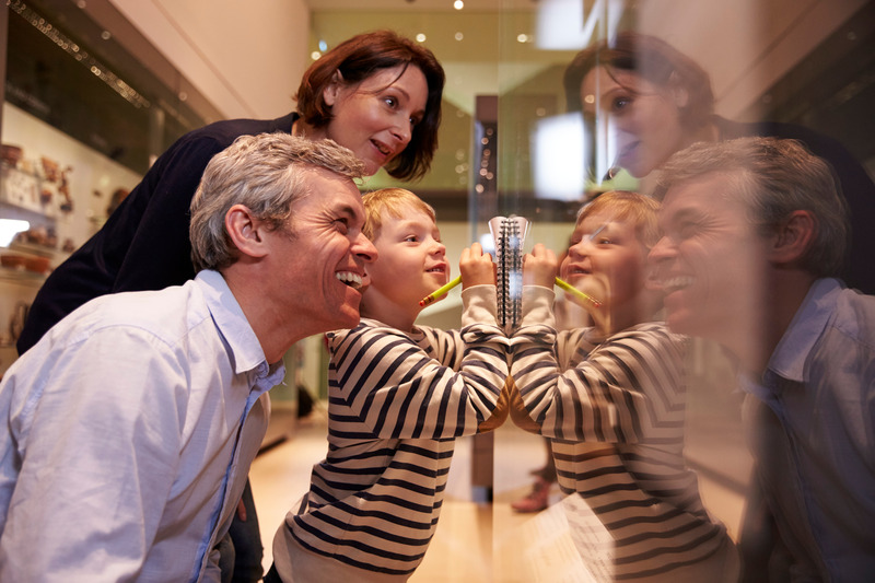Dentures patient at a museum smiling with family
