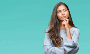 Woman tapping her chin in a questioning pose
